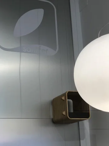 Montacargas de madera junto a lámpara esférica y logo Santifer — conexión entre mostrador y taller