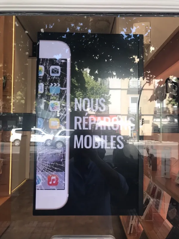 Pantalla digital en escaparate — reparación de móviles
